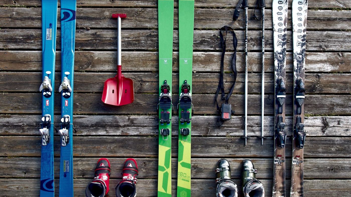Skis, poles and boots laid out on a wooden deck