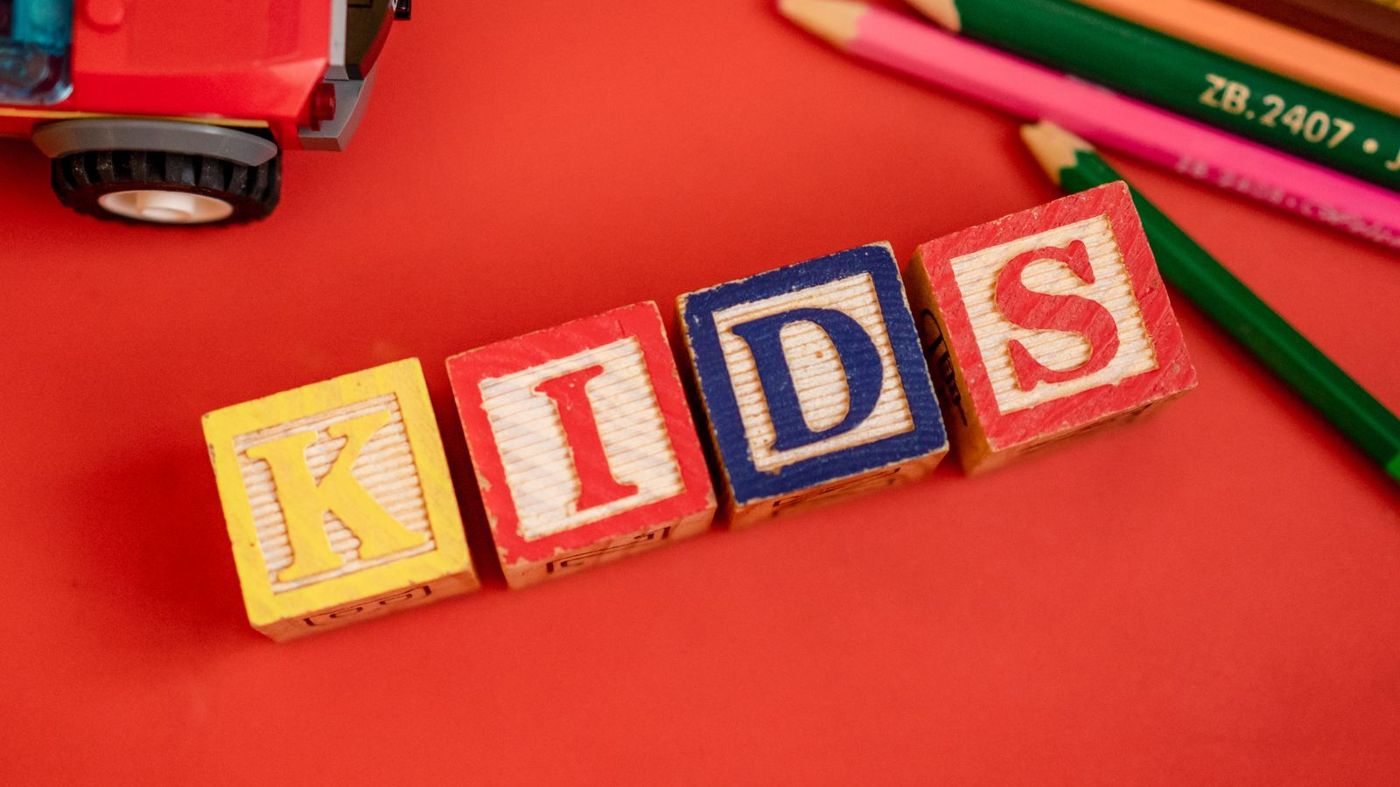 Colorful wooden alphabet blocks and toys on a red surface